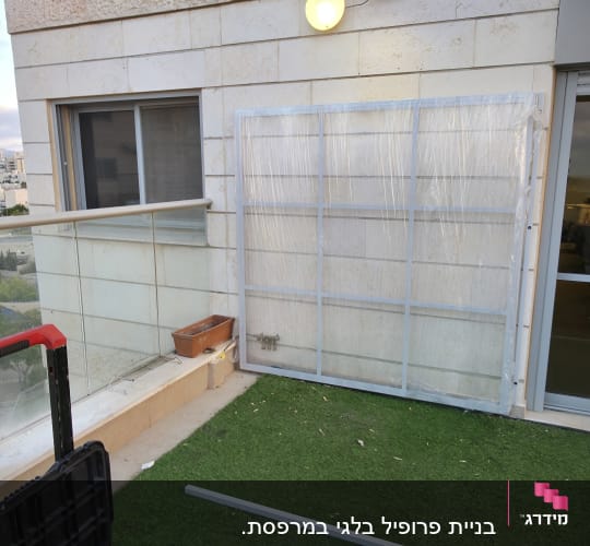 מסגרת מותקנת על קיר חיצוני עם כלים על הדשא